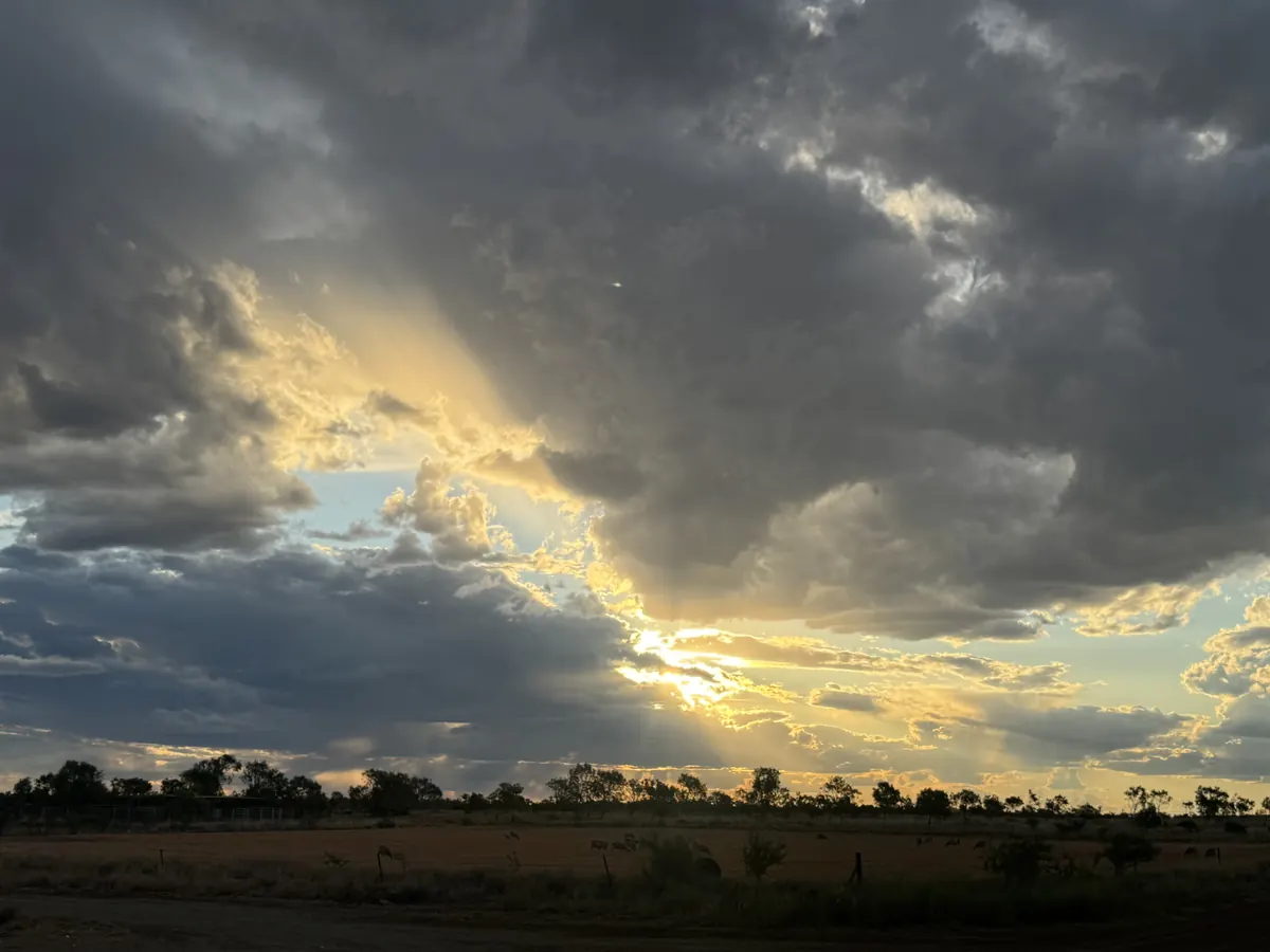 Storm clouds breaking over flat scrub country